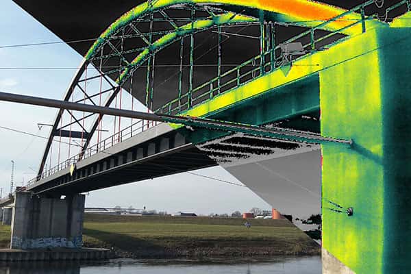 Geteiltes Bild einer Eisenbahnbrücke: Drohnenaufnahme zeigt Thermografie und Realbild zur Inspektion durch Multikopterdienst