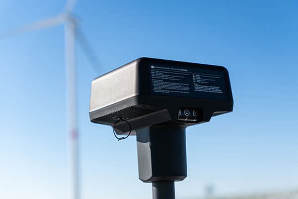 RTK-Basisstation von Multikopterdienst für Drohnenvermessung im Winter, Windräder im Hintergrund